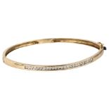 A modern 9ct gold diamond hinged bangle, channel set with modern round brilliant-cut diamonds, total