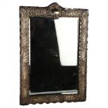 A large Edwardian silver dressing table mirror, rectangular form with relief embossed foliate