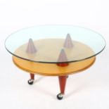 SANTA & COLE, a post-modern coffee table, with glass top on conical supports and ball casters,