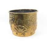 Dutch brass log bin, having lion mask ring handles, decorated with bowls of fruit, on a stepped
