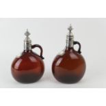 Pair of continental brown glass claret jugs, with silver plated mounts and covers, flattened