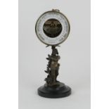 Brass cased holosteric barometer, supported on a base of brass cast as Don Quixote, polished slate