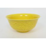 Chinese yellow ground moulded dragon bowl, 20th Century, the dragons chasing a flaming pearl