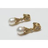 Pair of 18ct gold diamond and baroque pearl pendant earrings, the pearls approx. 10mm diameter,