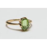 Peridot dress ring, the emerald cut stone of approx. 1ct in double claw mounts in 18ct yellow