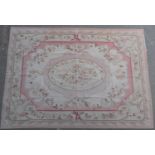 French Aubusson style flatweave carpet, centred with a floral oval reserve against a fawn ground,