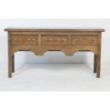 Oak low dresser in Georgian style, fitted with three short drawers with brass swan neck handles,