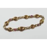Edwardian 15ct gold garnet and pearl bracelet, double strand crossover links dispersed with