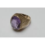 9ct gold amethyst signet ring, the oval cut stone of approx. 16mm x 12mm, in a reeded mount and