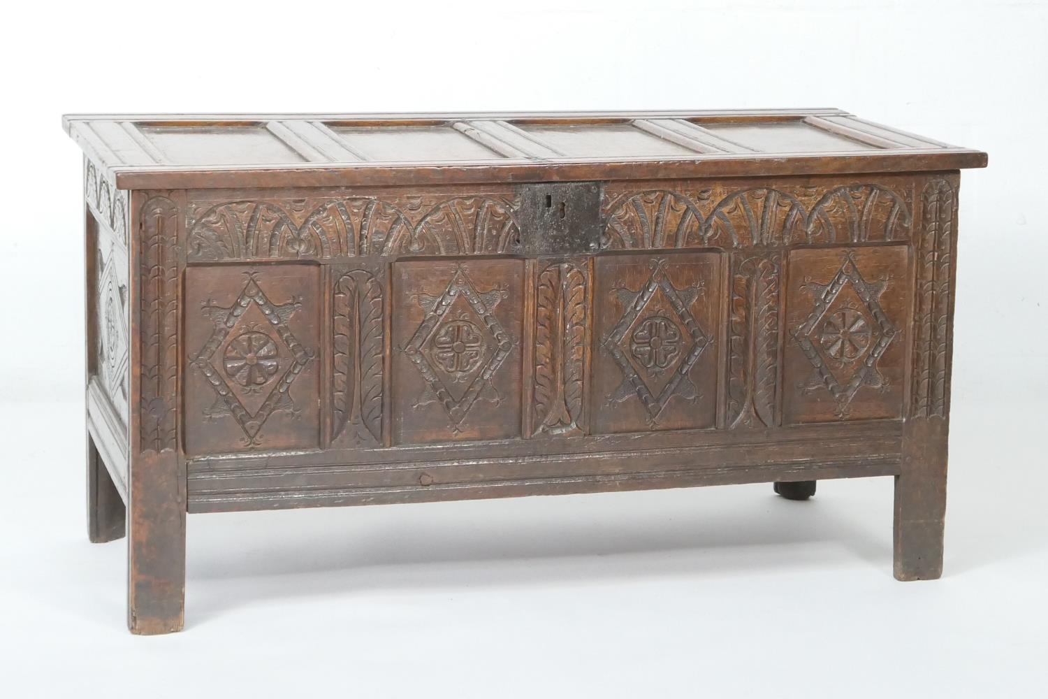 Oak joined coffer, late 17th Century, having a four recessed panel lid over a carved lunette