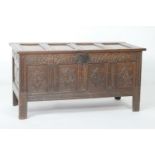 Oak joined coffer, late 17th Century, having a four recessed panel lid over a carved lunette