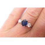 Sapphire and diamond three stone ring, the central oval cut sapphire of approx. 1ct flanked by two