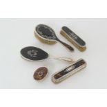 Five silver pique tortoiseshell vanity pieces comprising two hair brushes, London 1919 and