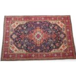 Tabriz woollen rug, red and fawn central medallion on a blue field dispersed with palmettes, fawn