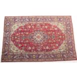 Tabriz woollen carpet, red field centred with a blue and fawn medallion, and with fawn spandrels and