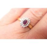 Ruby and diamond cluster ring, the central oval ruby of approx. 0.5ct, bordered with 14 small