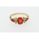 Diamond and orange gem set cluster ring, 18ct gold set with an oval cut central orange stone,