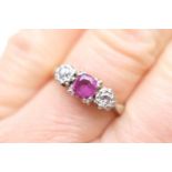 Diamond and ruby three stone ring, the central round cut ruby of approx. 0.5ct, in a claw mount