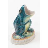 Unusual frog form match holder and striker, glazed colours on a bisque base, height 8cm