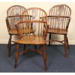 Three yewood and ash low back Windsor armchairs, early 19th Century, each with crinoline stretcher