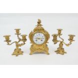 French gilt ormolu clock garniture, late 19th Century, the clock with Rococo cast base, white enamel