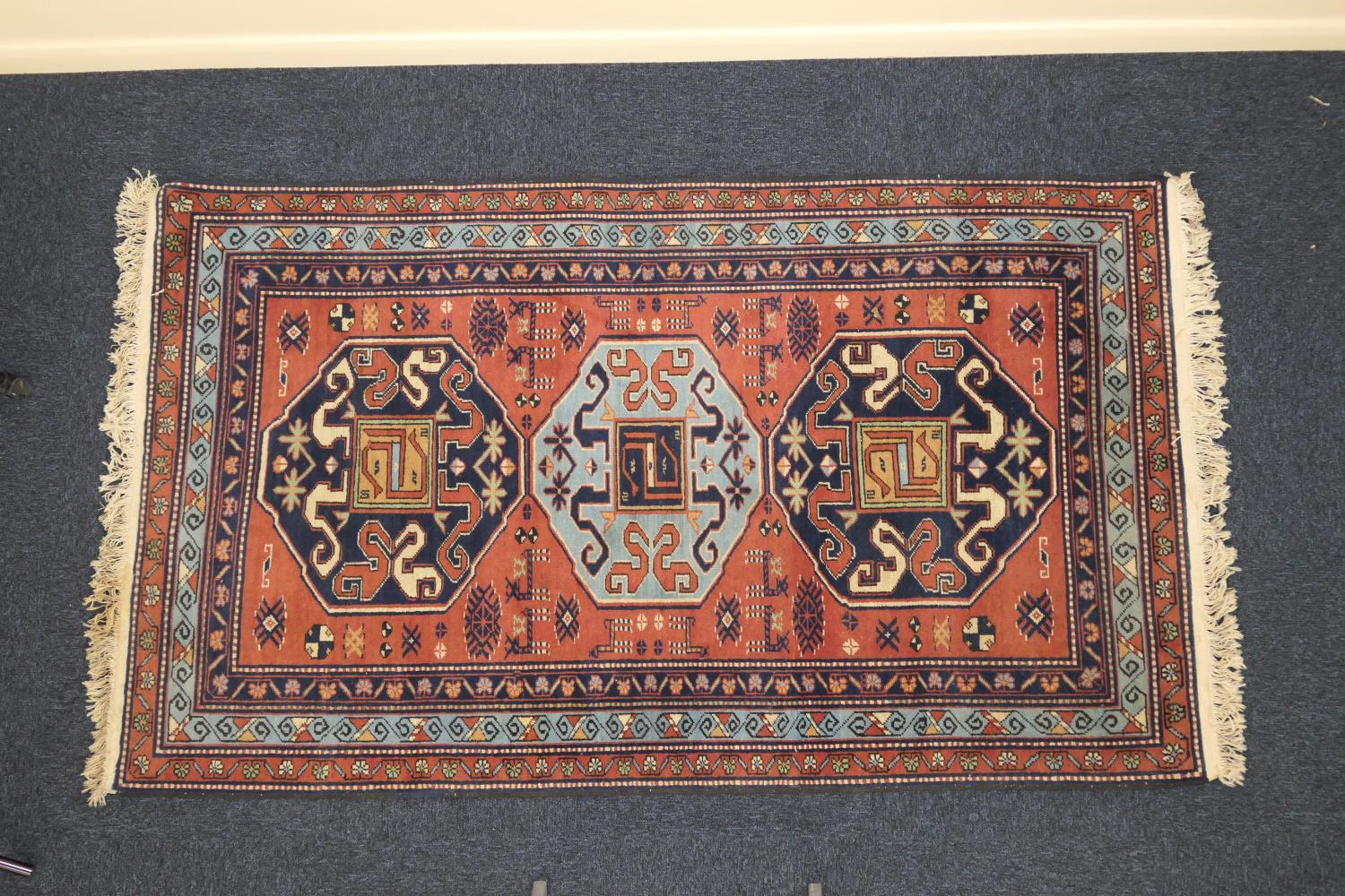 Modern Kazak woollen rug, the dusky pink ground dispersed with animals and with two dark blue