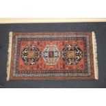 Modern Kazak woollen rug, the dusky pink ground dispersed with animals and with two dark blue