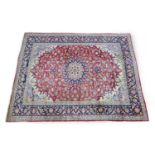 Iranian Tabriz woollen carpet, the red field with a central blue and fawn medallion dispersed with