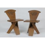 Unusual pair of handcrafted oak hall chairs, circa 1920-30, each having a foliate carved sloping
