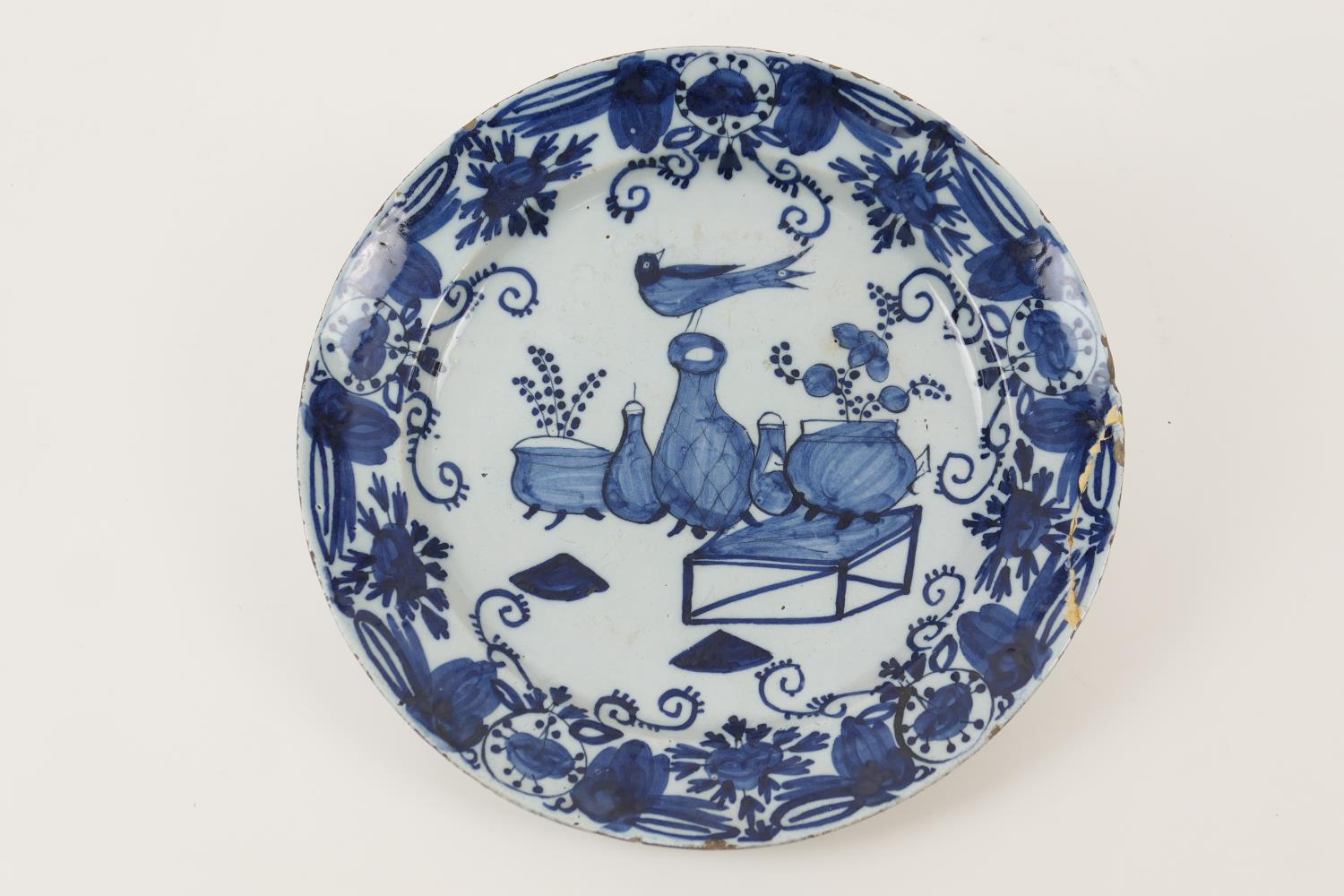 Delft blue and white dish, circa 1740-60, centred with a bird standing atop a vase in chinoiserie