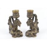 Pair of Renaissance style silvered bronze candlesticks, cast as griffons riding on the back of a