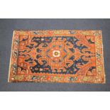 Shirvan woollen rug, abrashed blue ground centred with a hooked medallion in terracotta, blue and