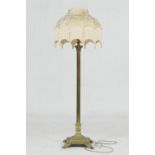 Brass corinthian column extendable standard lamp, having a gold damask and tasselled silk umbrella