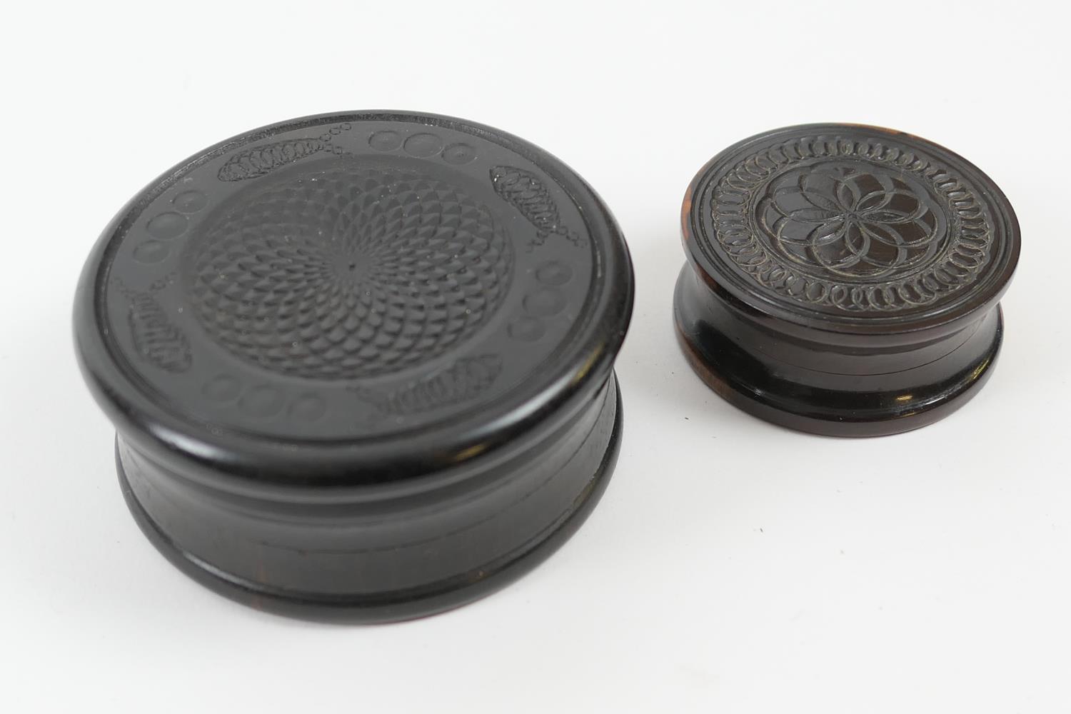 Two turned ebony circular snuff boxes, 8cm and 5cm diameter