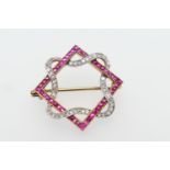 Diamond and ruby openwork brooch, formed as a square intertwined with a ribbon of diamonds, the