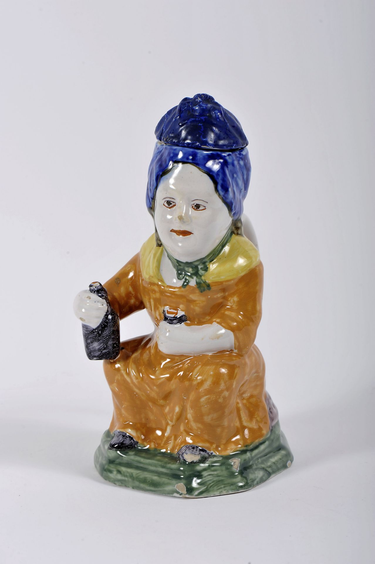 A covered jug "Seated female figure with bottle and glass"