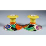 Gardenia, a Pair of Clarice Cliff Bizarre Candlesticks, shape no. 310, painted in colours, 3.25ins