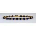 A 10ct Gold Sapphire Line Bracelet, Modern, set with twenty faceted sapphires, approximately 10ct in