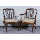 A Pair of Walnut Armchairs, with shaped and moulded backs and fretted splats, moulded scroll arms