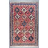 An Early 20th Century Shiraz Rug woven in ivory, navy blue and wine, the three rows of five hooked