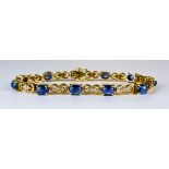 A Sapphire and Diamond Line Bracelet, Modern, 18ct gold set with eleven cabochon sapphires,