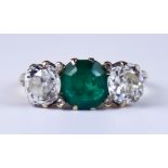A Late 19th/Early 20th Century Three Stone Emerald and Diamond Ring, yellow metal set with a