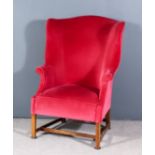 A Large Wingback Easy Chair of '18th Century' Design, with shaped wings and small out scrolled arms,