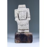 A Central Mexican Carved Volcanic Stone Standing Figure of a God, arms resting across its chest, 9.