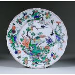 A Chinese Kangxi Famille Verte Plate, enamelled with flowering branches, rock work and birds, blue