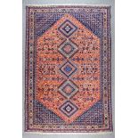 An Early 20th Century Shiraz Carpet woven in colours of ivory, navy blue and terracotta, with five