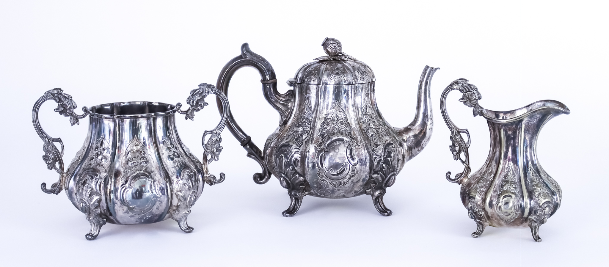 A 19th Century Indian Silvery Metal Three-piece Tea Service, of baluster panelled form embossed with