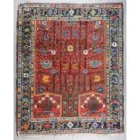 An Early 20th Century Khamseh Rug woven in colours of ivory, fawn, navy blue and wine, field filled