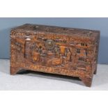 A Chinese Carved Camphorwood Chest, the whole carved with narrative Oriental scenes, with rose and