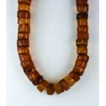 A 20th Century String of Reconstituted Amber Beads, comprised of amber discs, approximately 1200mm